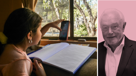 Mädchen am Schreibtisch mit Handy und Schulbuch