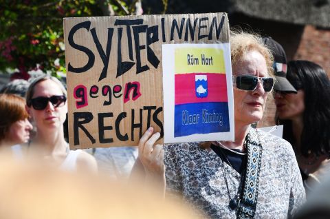 SylterInnen gegen Rechts“ steht auf einem Schild, dass eine Frau bei einer Mahnwache in der Hand hielt. 