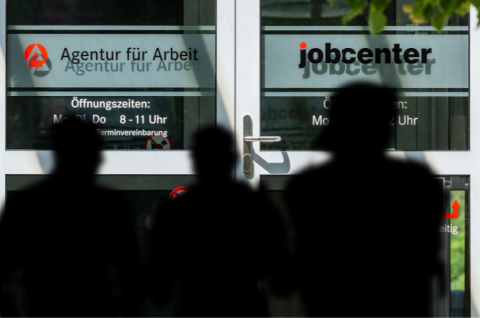Junge Männer warten vor einem Jobcenter