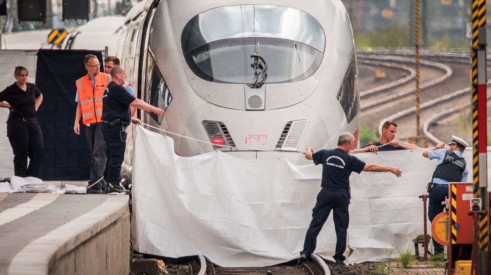 29.07.2019, Hessen, Frankfurt/Main: Polizisten und Feuerwehrleute spannen im Hauptbahnhof eine weiße Plane als Sichtschutz vor einen ICE. Ein achtjähriger Junge ist im Frankfurter Hauptbahnhof von einem Mann vor den einfahrenden ICE gestoßen und getötet worden. Ein Tatverdächtiger wurde festgenommen, wie die Polizei mitteilte. Der Mann soll auch die Mutter des Jungen ins Gleisbett gestoßen und es bei einer weiteren Person versucht haben.