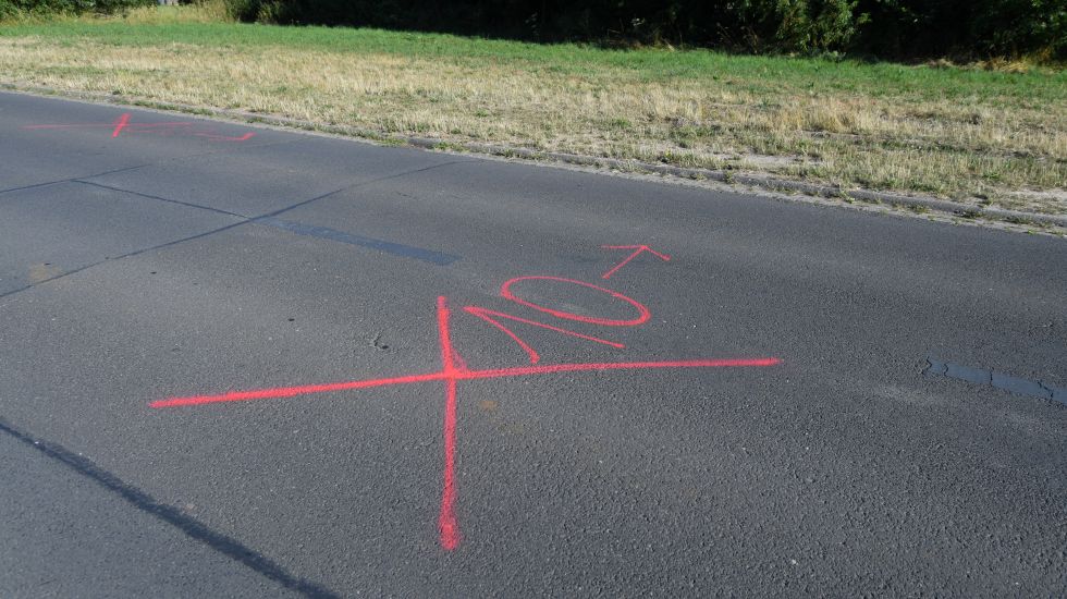 Nahe des Sportplatzes des TSV Kassel sind rote Markierung auf dem Asphalt zu sehen.