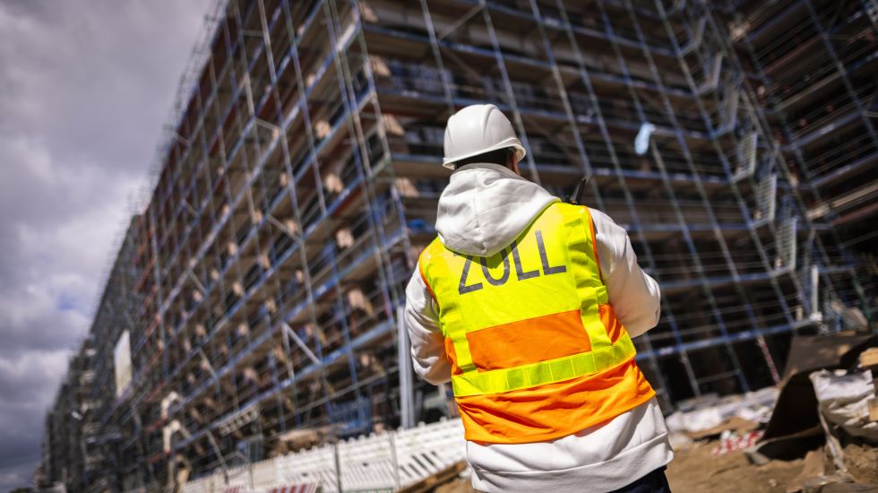 Ein Zollbeamter steht an einer Baustelle bei einer Ueberpruefung zum Thema Schwarzarbeit in Berlin,